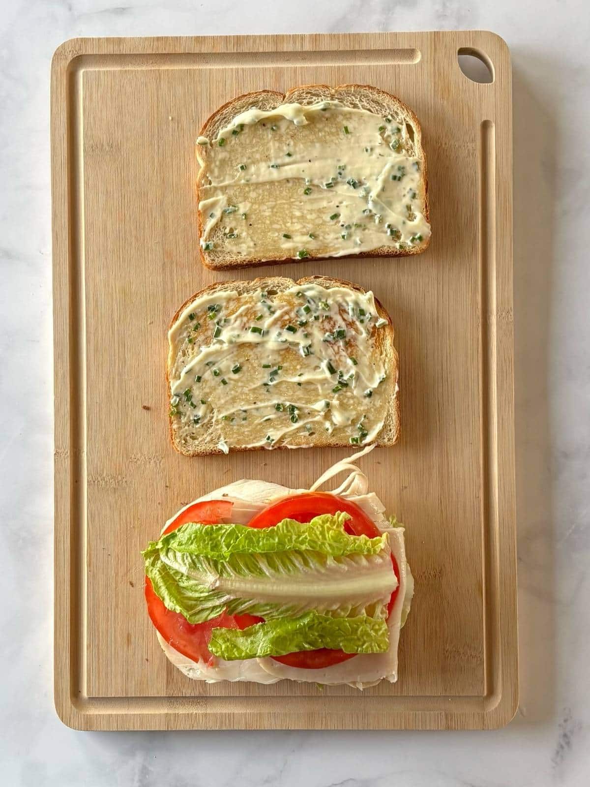 Assembling the first layer of the sandwich on a cutting board.