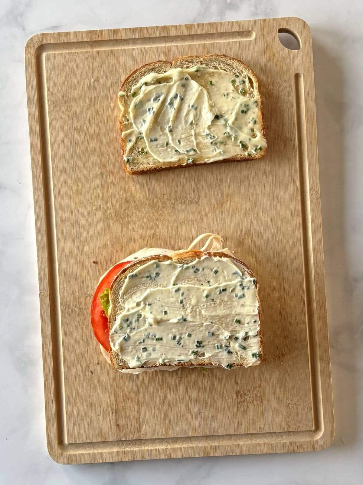 The first sandwich layer topped with a second slice of bread.