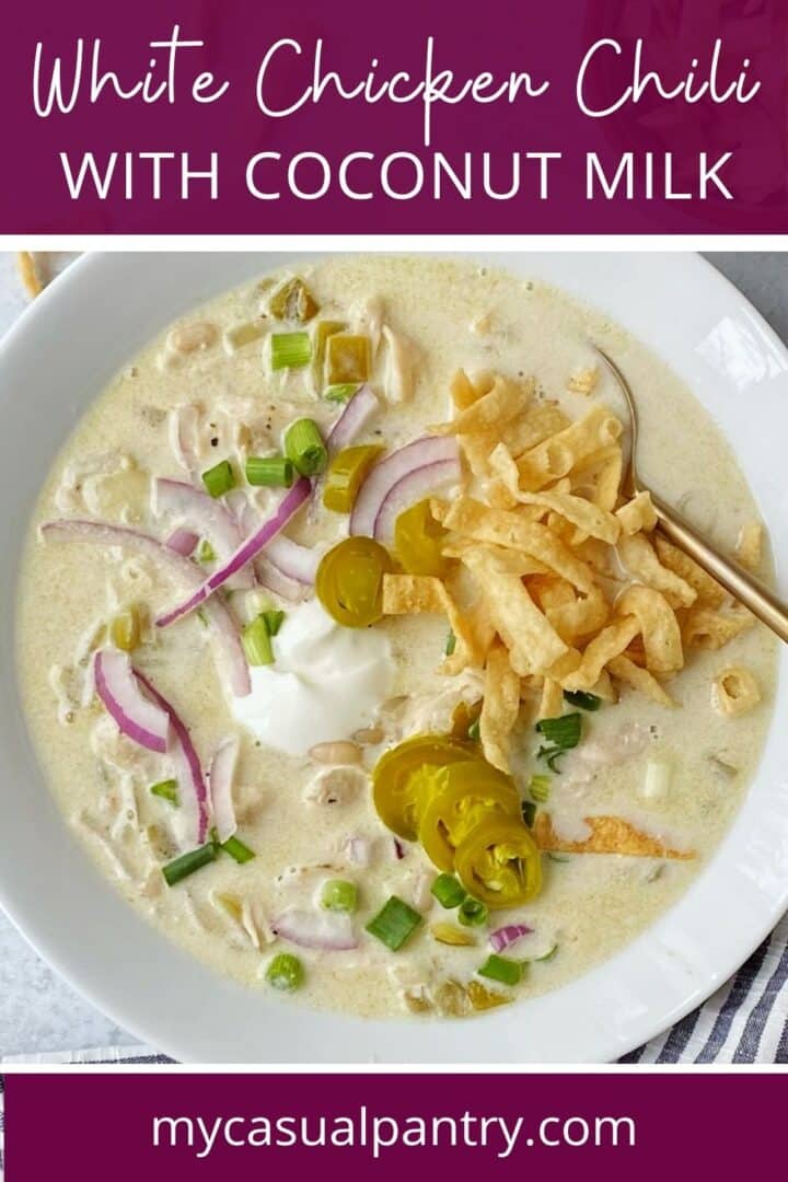 A bowl of chicken chili topped with garnishes.