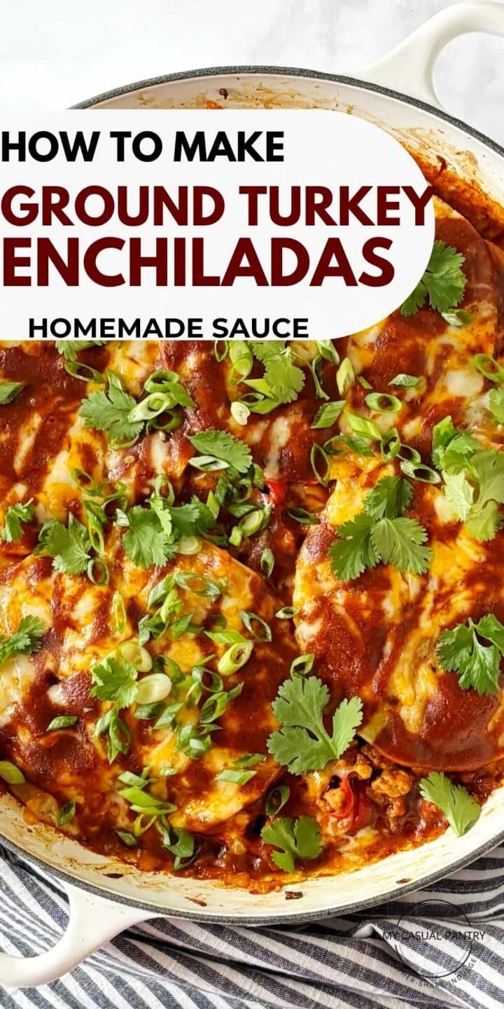 A skillet of layered turkey enchiladas garnished with scallions and cilantro.