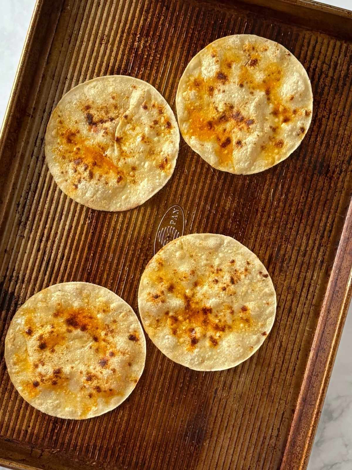 A sheet pan with toasted tortillas.