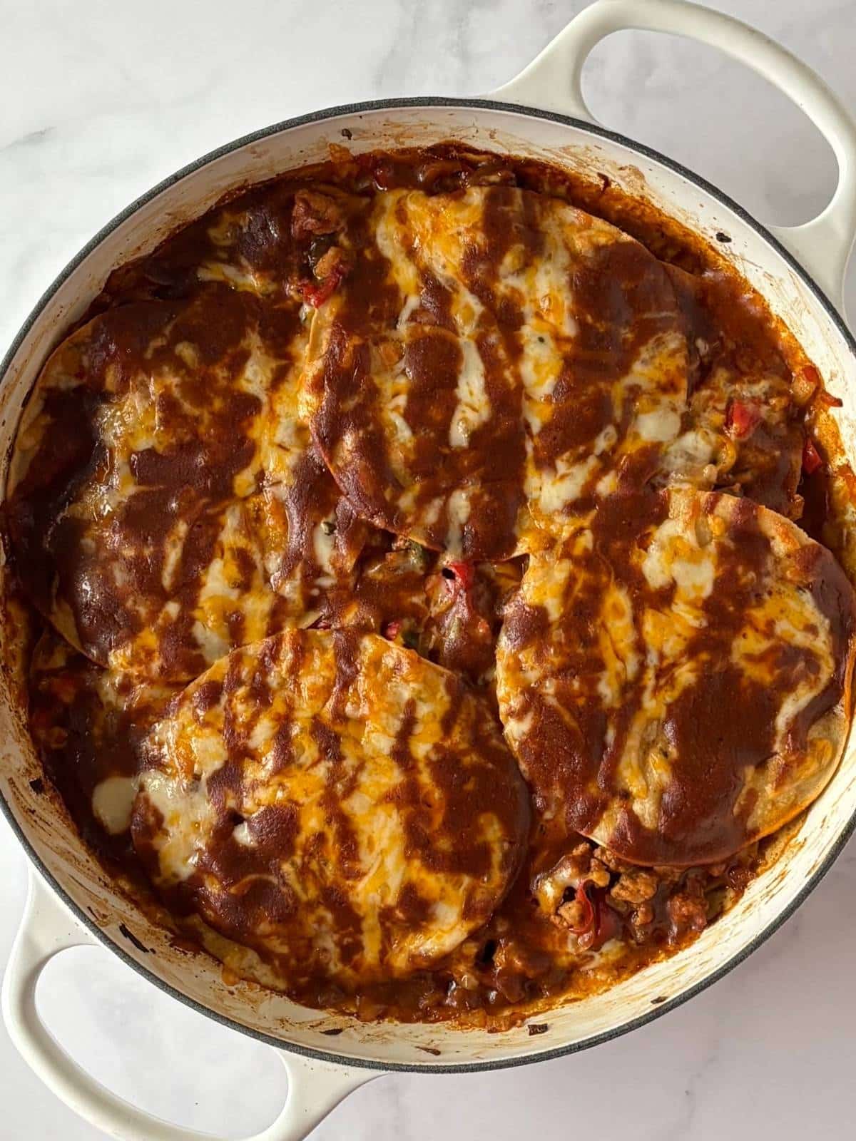 A skillet of baked turkey enchiladas.