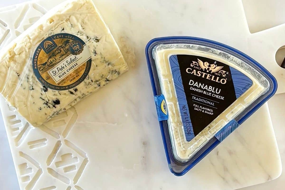 Two types of blue cheese on a marble board.