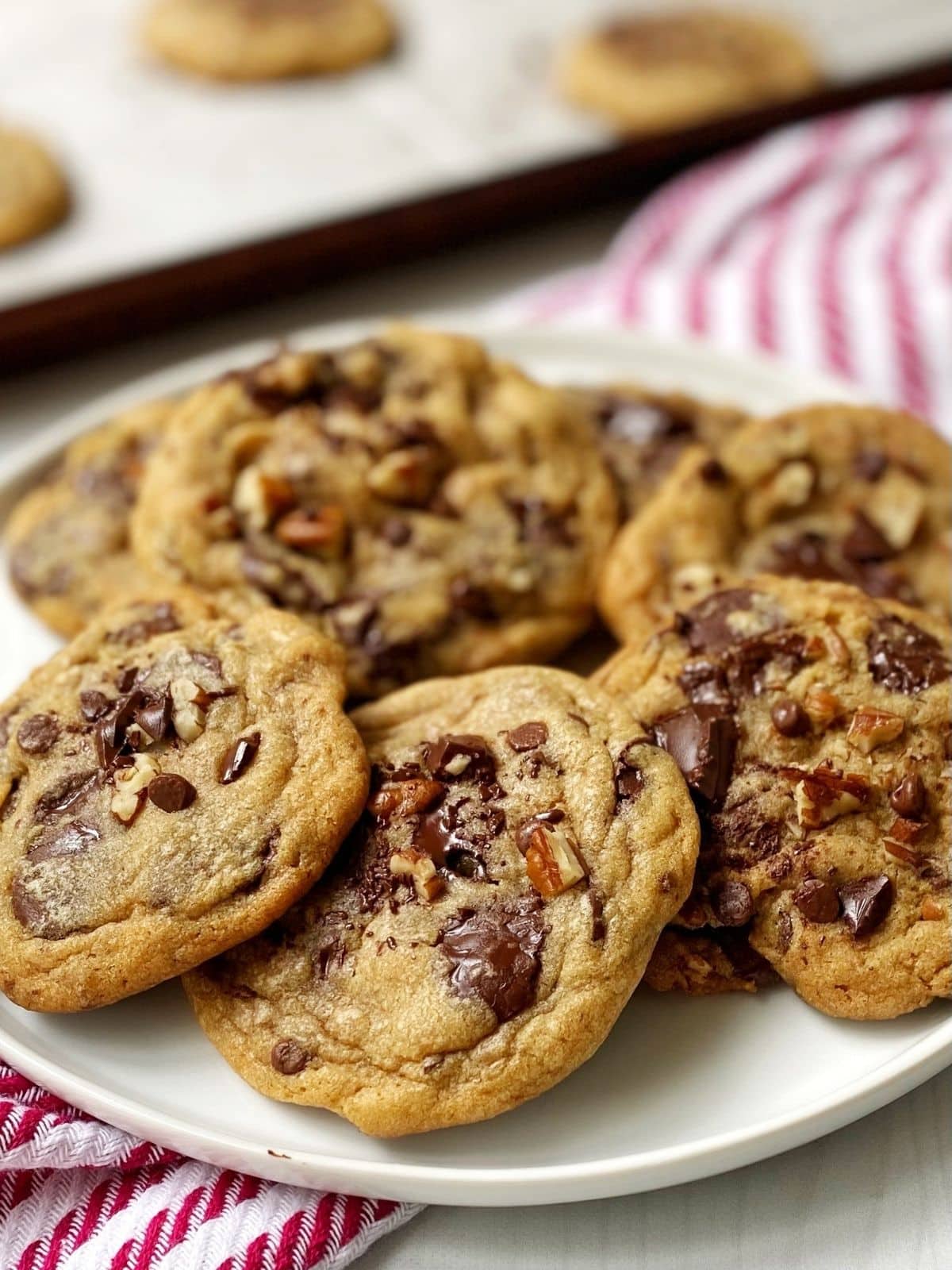 Cookies on a plate next to the baking sheet of cookies.